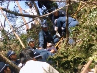 米軍北部訓練場内での抗議行動で、警察官にロープで縛られ引き上げられる市民（中央）＝２８日（提供）