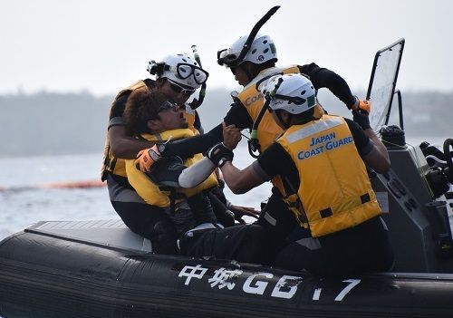 カヌーで抗議していた男性（左から２人目）をゴムボート上で確保する海上保安官＝2015年6月５日、名護市辺野古沖