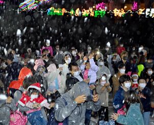 降り注ぐ人工の雪に歓声を上げる子どもたち＝１８日、沖縄市・沖縄こどもの国（田嶋正雄撮影）