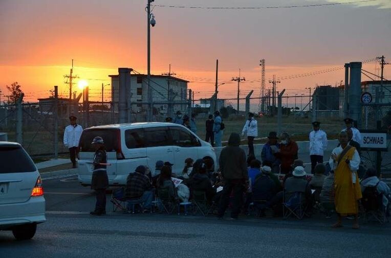 日の出前から抗議集会を始める座り込みの住民ら＝２６日午前７時１５分ごろ、名護市のキャンプ・シュワブゲート前