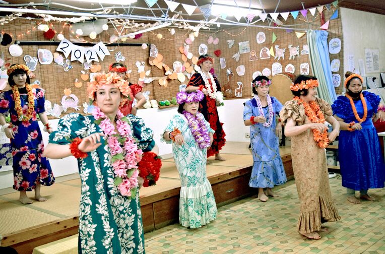 合同誕生日でフラダンスを披露する職員＝沖縄市、デイサービスセンターエデンの園