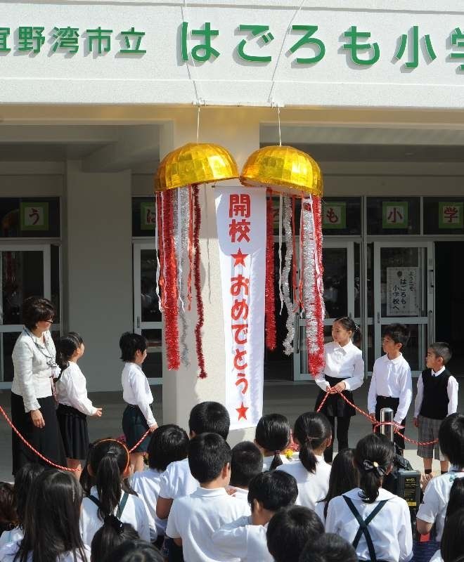 はごろも小学校の開校式で、くす玉を割る子どもたち＝５日午前、宜野湾市大山の同校