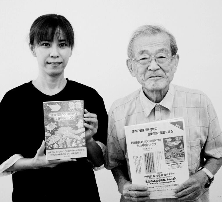 本を紹介する沖縄長寿科学研究センターの鈴木信さん（右）、前田のぞみさん＝３日、浦添市