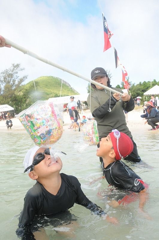 渡名喜小中学校伝統の水上運動会で障害物競走を楽しむ子どもたち＝２５日、あがり浜
