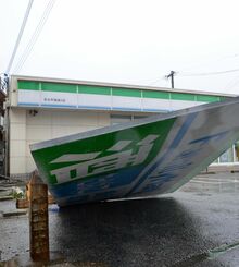 暴風で支柱が折れて倒れた看板＝２３日午後１時１０分ごろ、宮古島市平良下里
