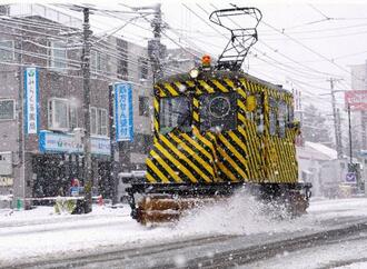 　今季初めて出動し、線路に積もった雪を掃き飛ばす「ササラ電車」＝２日午前、札幌市