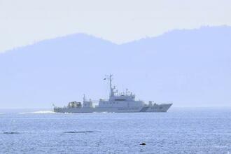 　１１日、北海道・知床半島の羅臼港沖合を航行する海上保安庁の巡視船。後方は北方領土・国後島