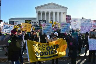 　米連邦最高裁前でプラカードや横断幕を掲げる人工中絶擁護、反対両派の人たち＝１日、米ワシントン（共同）