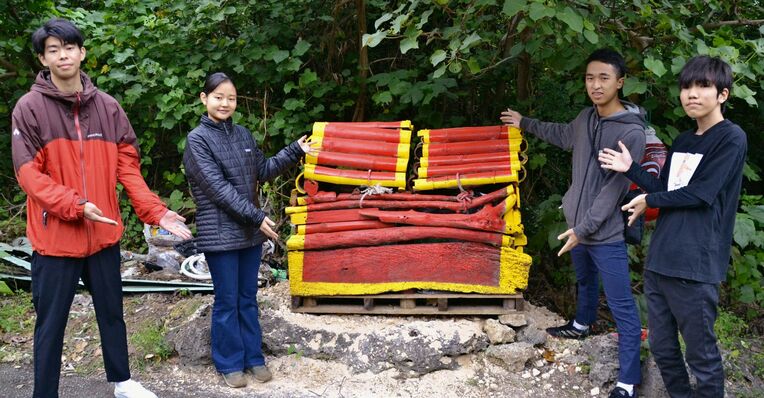 漂着ごみの木材やロープなどで手作りした「ニライカナイの宝箱」をＰＲする寺澤彩来紗さん（左から２人目）らメンバー＝２０２２年１２月２７日、石垣市の大浜海岸