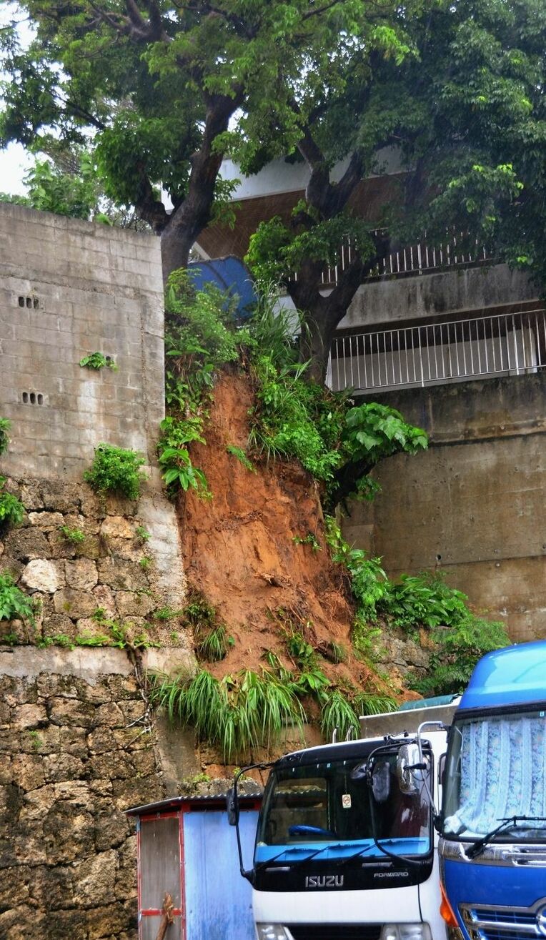 土砂崩れがあった民間駐車場の斜面＝１３日、浦添市城間