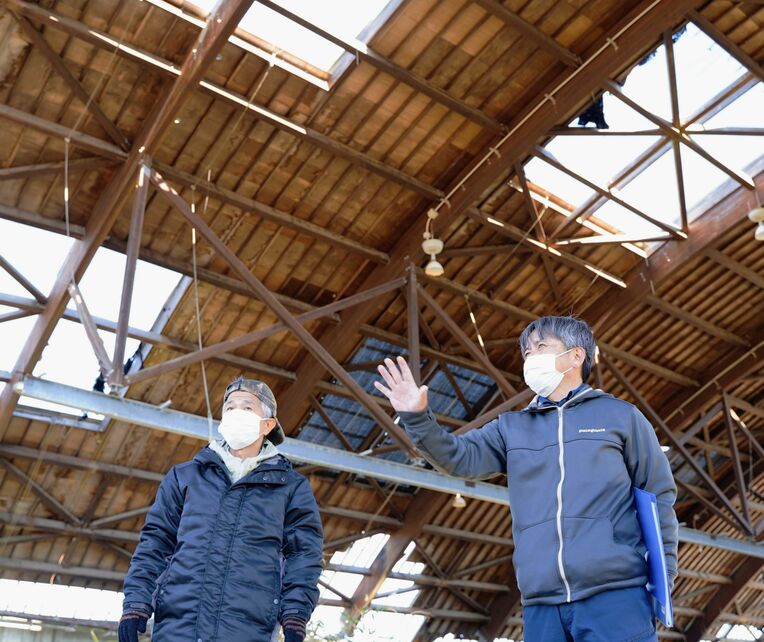 「福島の不条理を知ってほしい」と、木村紀夫さん（右）は具志堅隆松さんを廃墟となった養殖場跡に案内した＝２日、福島県大熊町