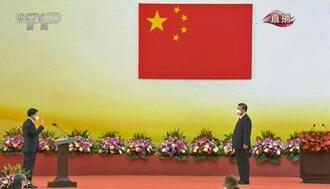 　香港返還２５年記念式典で、中国の習近平国家主席（右）に就任の宣誓をする香港特別行政区の李家超新長官。中国中央テレビが１日放映した（共同）