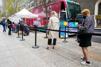 　６日、米ニューヨーク・マンハッタンで、新型コロナワクチン接種用バスの列に並ぶ人々（ＡＰ＝共同）