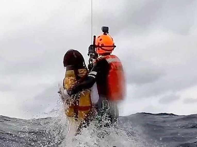 機動救難士に救助される女性（第１１管区海上保安本部提供映像より）