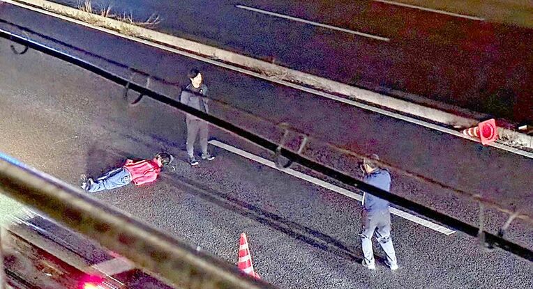 死亡した女性が倒れていた位置に人形を置き、タクシーからの見え方を調べる捜査員＝３日午前３時３５分ごろ、宜野湾市大山の国道５８号