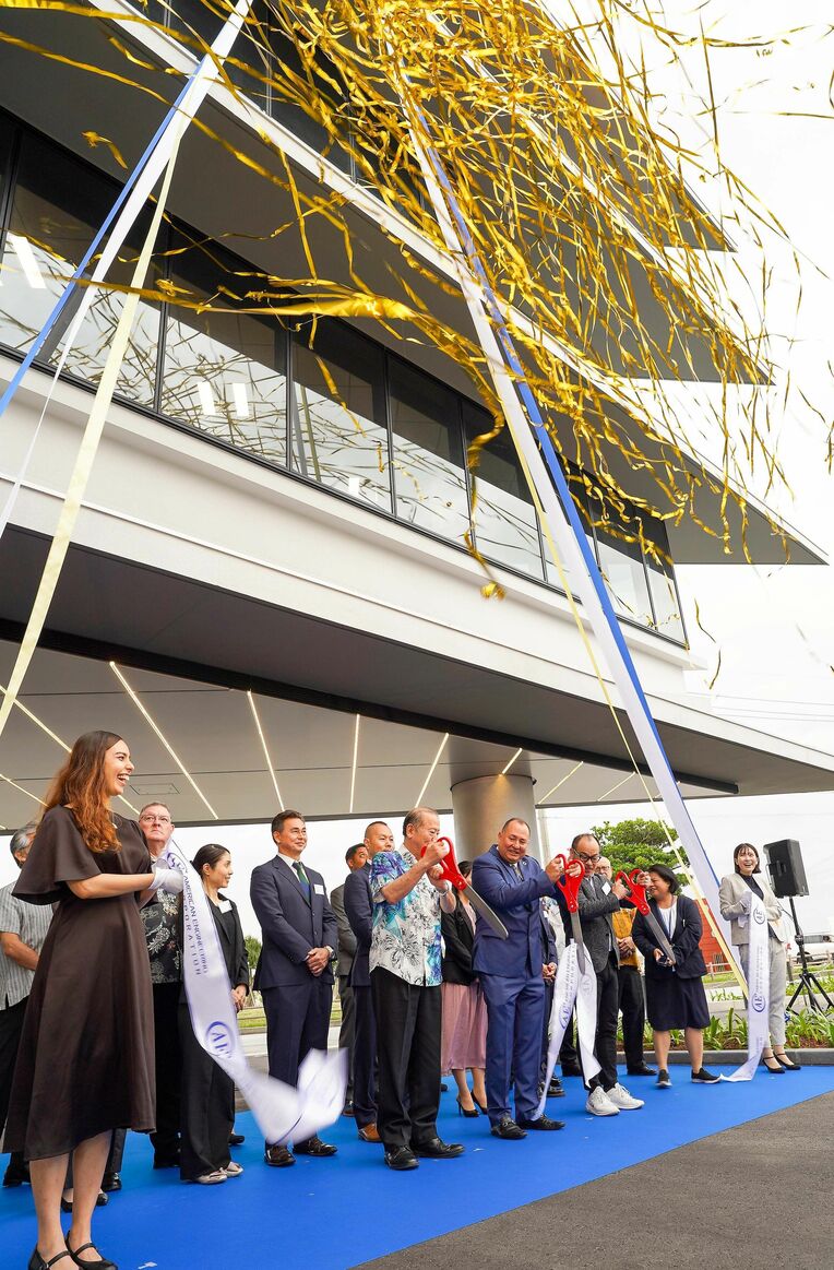 アメリカンエンジニアコーポレーション創立６０年を記念して建設された新社屋の落成を祝う関係者ら＝１２日、宜野湾市大山