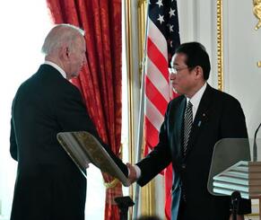　共同記者会見を終え、握手する岸田首相（右）とバイデン米大統領＝２３日午後、東京・元赤坂の迎賓館（代表撮影）