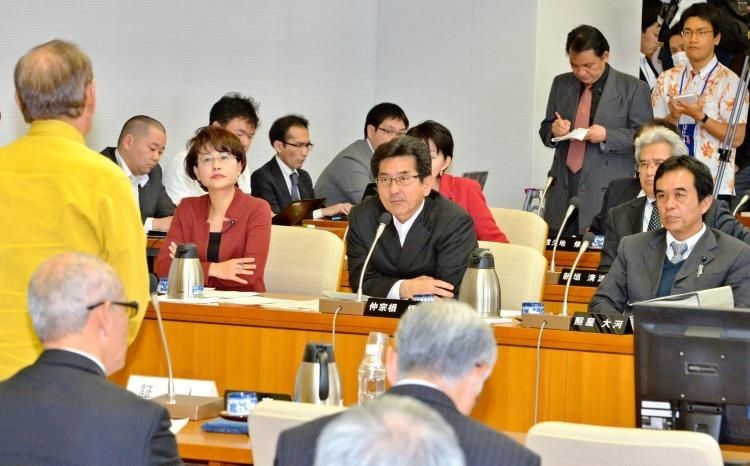 仲井真弘多知事（左端）の答弁を聞く委員ら＝２１日午後、県議会