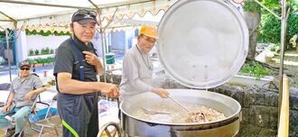 比嘉真栄さん（手前右）から伝統料理「チー汁」を教わる松田清光さん＝２２日、楚辺公民館