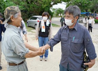 具志堅隆松さん（左）と再会を喜ぶ木村紀夫さん＝１６日、糸満市