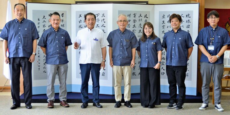 桑江朝千夫市長（左から３人目）へ市観光物産振興協会の新役員体制を報告した島袋隆会長（同４人目）ら同協会の役員ら＝１０日、沖縄市役所