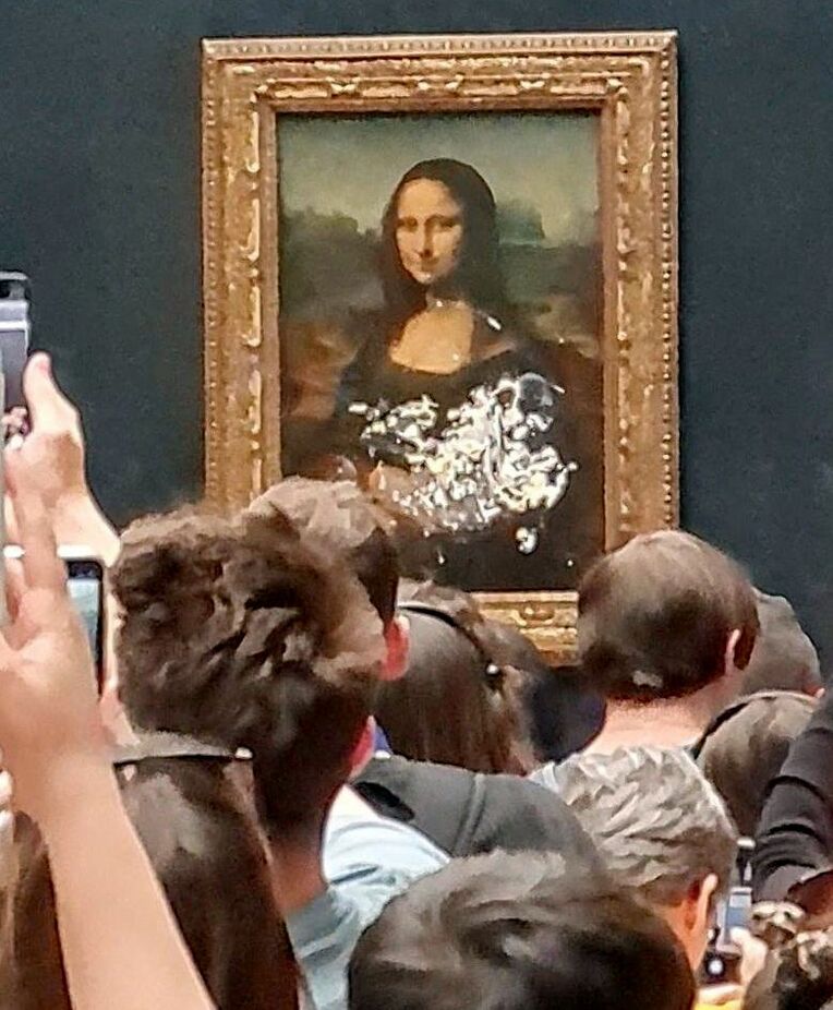 ２９日、パリのルーブル美術館で、強化ガラス上にクリームが付着した「モナリザ」を撮影する人々（＠ｋｌｅｖｉｓｌ００７のツイッターより、ロイター＝共同）