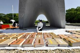 　原爆慰霊碑前で行われた、原爆死没者名簿の「風通し」＝１８日午前、広島市の平和記念公園
