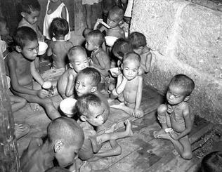 城間繁雄さんが弟と約３カ月過ごしたというコザ孤児院。写っているのは、食事をする子どもたち＝１９４５年８月４日（県公文書館所蔵）
