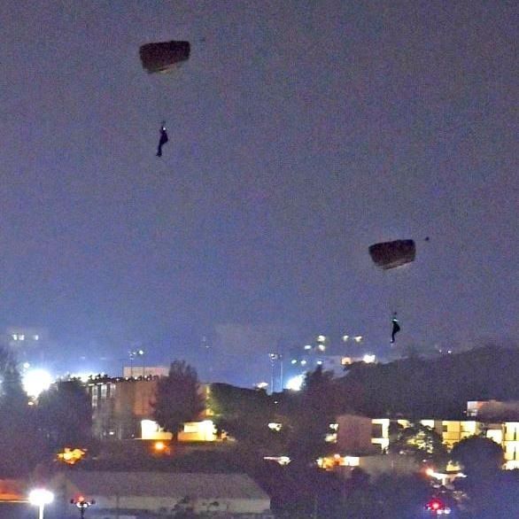 米軍嘉手納基地で夜間にパラシュートで降下する米兵＝2017年5月10日午後8時3分、嘉手納町役場から（金城健太撮影）