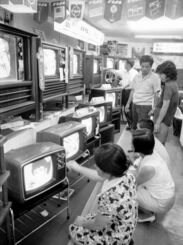 カラーテレビ、クーラー、自動車の３Ｃブーム。家電量販店で憧れのカラーテレビを品定めする県民ら＝１９７２年８月２２日、那覇市