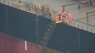 貨物船に救助される「第二十八克丸」の乗組員ら＝20日午後0時50分ごろ、沖縄県内(第11管区海上保安本部提供)