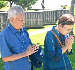 沖縄戦で亡くなった父盛一さんに「これが最後だよ」と手を合わせる中野光政さん（左）と、妻の志津江さん＝２３日、糸満市摩文仁・平和の礎