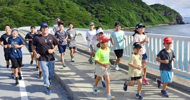 練習前のジョギングをする阿嘉陸上クラブの子どもたち＝座間味村・阿嘉島（新崎哲史撮影）
