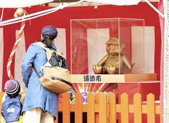 浦添市のプロ野球・ヤクルトのキャンプ地に登場したつば九郎神社。ファンが金のご神体「きんつば」に連覇祈願していました＝１０日