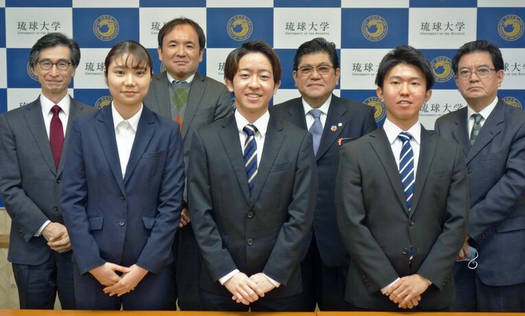 県工業製品の県内自給率を調査した琉球大学の獺口浩一教授（後列左から２人目）と学生や関係者ら＝２４日、西原町・琉球大学