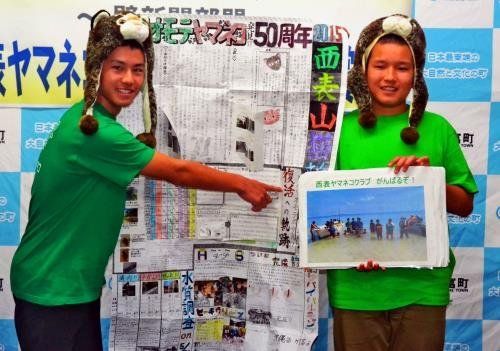 文部科学大臣賞を受賞した壁新聞を前に笑みを浮かべる石田さん（左）と竹内さん＝竹富町役場