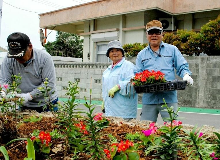 「花いっぱいの島に」と作業に精をだす村老人クラブ会員＝３月３１日、伊江村