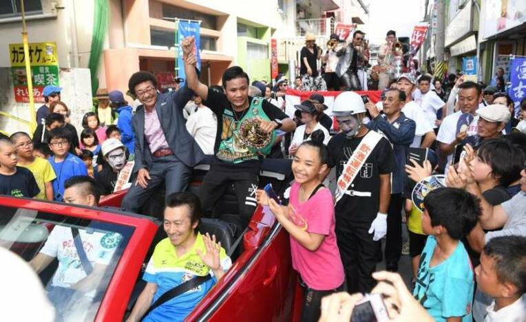 Yoko Gushiken (left) joins the celebration after his apprentice Daigo Higa (center) wins the WBC flyweight title, during a parade on June 11 in Miyakojima, Okinawa Prefecture. | THE OKINAWA TIMES