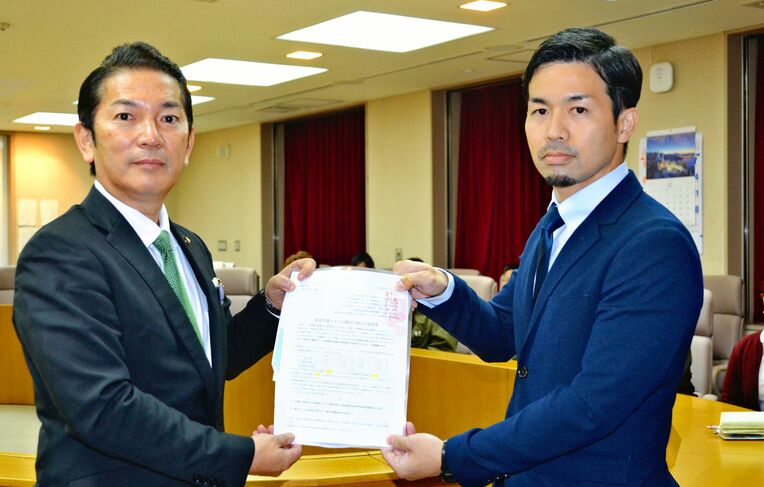 保護者を代表して松本哲治市長（左）に要望書を提出する高良光さん＝２０２２年１２月２３日、浦添市役所