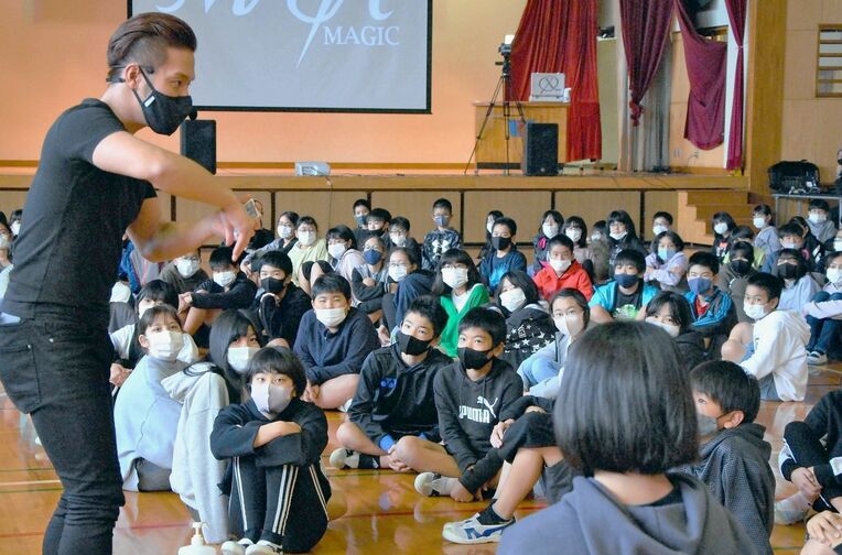 ＭＡＳＡマジックさん（左）のマジックに見入る児童ら＝１０日、沖縄市の宮里小学校