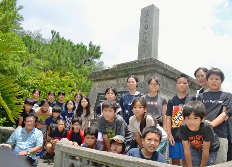 「第二護郷隊之碑」の前で写真に納まる安富祖小の５、６年生ら＝２１日、恩納村安富祖