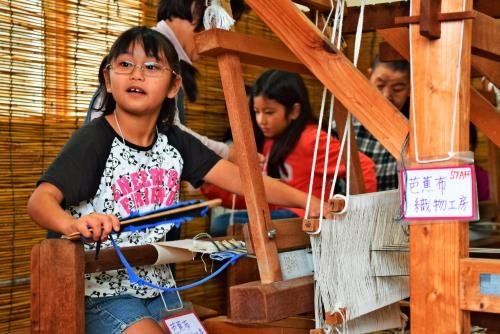 本物のはた織り機を使って芭蕉布織りを体験した子供たち