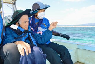 抗議船「平和丸」の船上から、新基地建設現場を見る上間正敏さん（左）＝２４日午後１時４７分、名護市辺野古沖