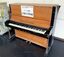 名護小学校で使われないまま長く保管されていたとみられる明るい木目のピアノ＝ネオパークオキナワ