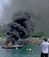 爆発後、船体後部から炎と黒煙が立ち上るプレジャーボート＝４月２７日午前１０時２０分ごろ、本部町の山川漁港（提供）