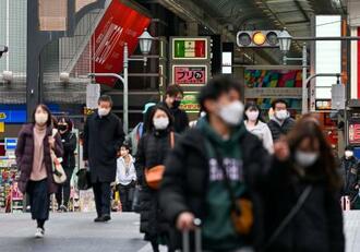　大阪・ミナミの繁華街を歩くマスク姿の人たち＝１４日午後