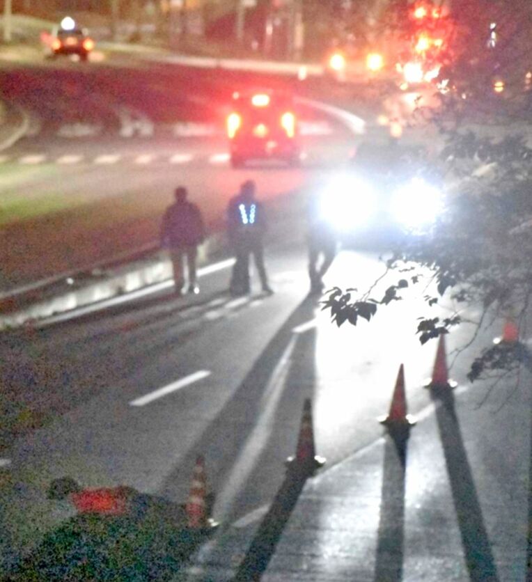 女性が倒れていた位置に人形を置き、事故時の様子を詳しく調べる捜査員ら＝３日午前３時１５分、宜野湾市大山の国道５８号