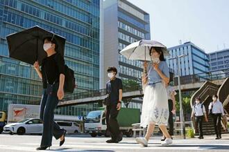 　強い日差しの中、日傘を差して歩く人たち＝１日午前、名古屋市