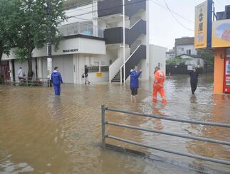 大雨で道路が冠水し、膝下ほどまで水があふれていた＝１８日、名護市大東