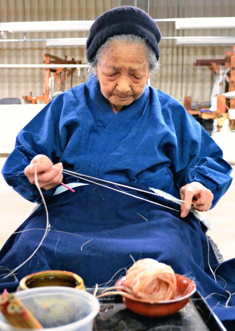 芭蕉の繊維から糸をうむ平良敏子さん＝１３日、大宜味村喜如嘉・芭蕉布会館